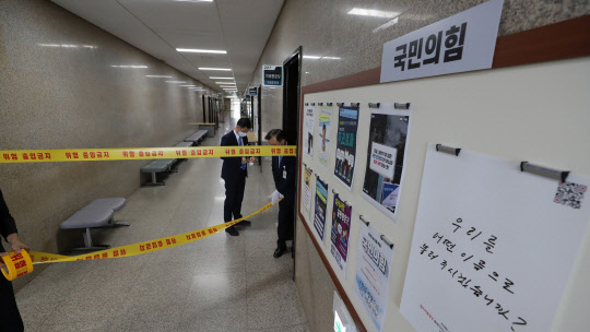 국회 방호요원들이 3일 코로나19 확진자가 발생한 국회 본청 일부를 폐쇄하고 있다. 연합뉴스